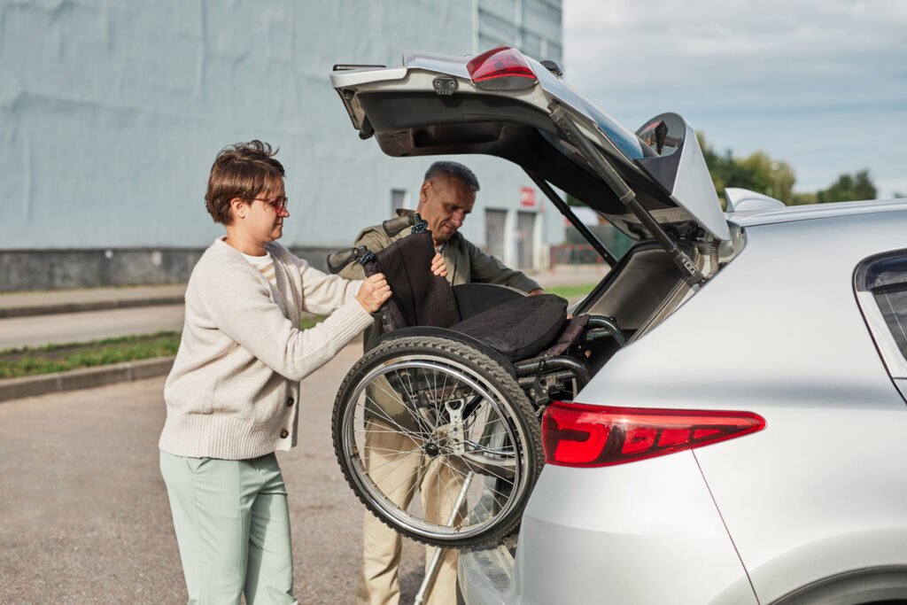persona guardando silla de ruedas eléctrica en el coche